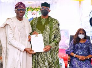 L-R: Lagos State Governor, Mr. Babajide Sanwo-Olu, presents a State condolence letter to his Ogun State counterpart, Prince Dapo Abiodun over demise of his father, Pa Emmanuel Abiodun in Iperu-Remo, Ogun State on Sunday, August 22, 2021. With them is wife of the Ogun State Governor, Mrs. Bamidele Abiodun.